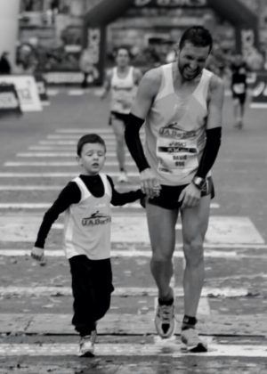 runner entrando en meta de una maraton con su hijo